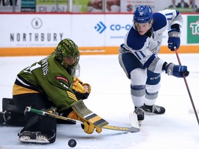 Landon McCallum of the Sudbury Wolves tries to get the puck past North Bay Battalion goalie Dom Divincentiis during OHL action from the Sudbury Comminuty Arena on Sunday afternoon.