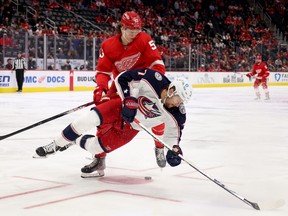 DETROIT, MICHIGAN - OCTOBER 19: Sean Kuraly #7 of the Columbus Blue Jackets looses his footing while being checked by Moritz Seider #53 of the Detroit Red Wings during the third period at Little Caesars Arena on October 19, 2021 in Detroit, Michigan. (Photo by Gregory Shamus/Getty Images)