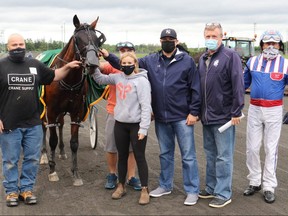 Jeff Seibel, left, Kendal Middleton, James Grant, Dave Walls and driver Sylvain Filion pose with horse Bob Loblaw after his first career win in an Ontario Sires Stakes Grassroots Series race July 9, 2021, at Woodbine Mohawk Park in Milton, Ont. (Clive Cohen/New Image Media)