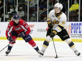 Sarnia Sting's Cameron Supryka, right, protects the puck from Windsor Spitfires' Wyatt Johnston in the first period at Progressive Auto Sales Arena in Sarnia, Ont., on Friday, Oct. 8, 2021. Mark Malone/Chatham Daily News/Postmedia Network