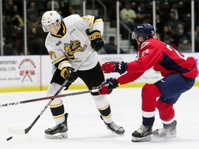 Sarnia Sting's Ryder McIntyre, left, protects the puck from Windsor Spitfires' Bronson Ride in the first period at Progressive Auto Sales Arena in Sarnia, Ont., on Friday, Oct. 8, 2021. Mark Malone/Chatham Daily News/Postmedia Network