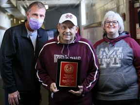 Chatham Maroons equipment manager Randy DeWael, centre, is joined by his wife, Robin, to receive the 2019-20 GOJHL Western Conference Convenor's Award from team owner Bill Szekesy at Chatham Memorial Arena in Chatham, Ont., on Sunday, Oct. 17, 2021. Mark Malone/Chatham Daily News/Postmedia Network