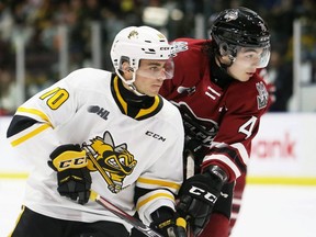 Sarnia Sting's Ben Lalkin, left, battles Guelph Storm's Michael Buchinger in front of the Storm's net in the first period at Progressive Auto Sales Arena in Sarnia, Ont., on Friday, Oct. 22, 2021. Mark Malone/Chatham Daily News/Postmedia Network