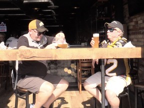 Robert Blunsdon (left) and Andy Calvert enjoy a few beers and wings at Winporium on Barton St. before the Toronto Argos-Hamilton Ticats game at Tim Hortons field on Monday, Oct. 11, 2021.