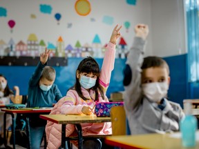 Elementary school children wearing face masks in the classroom.