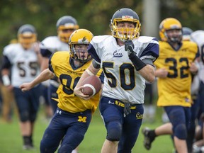 College Avenue Knights ball carrier Aidan George puts distance between himself and Owen Dixon of the Montcalm Cougars in a Thames Valley Regional Athletics game Thursday in Woodstock. The home team won 58-0. (Derek Ruttan/The London Free Press)