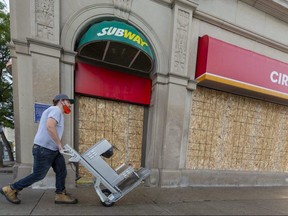 Workers remove equipment from the Circle K and Subway location at Wellington and Dundas streets in London on Sept. 30, 2020, after the store closed permanently the day before. Driving prosperity is one of three guiding principles in a framework for the city's recovery from the COVID-19 pandemic that was released Wednesday. (Mike Hensen/The London Free Press)