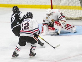 Sarnia Legionnaires goalie Nolan DeKoning makes a save against Komoka Kings’ Alex MacLeod as Legionnaires’ Reed Stauffer trails the play in the first period at Sarnia Arena in Sarnia, Ont., on Thursday, Oct. 7, 2021. (Shawna Lavoie Photography)