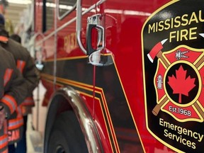 Mississauga Fire truck with firefighters standing nearby.