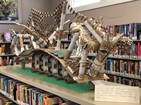 Paisley neighbours created this pandemic-inspired sculpture: a horse jumping a hurdle representing COVID-19, using toilet paper rolls, paper towel rolls, take-out boxes and online order packaging. It's on display at the public library in Paisley. (Judi Bond photo)