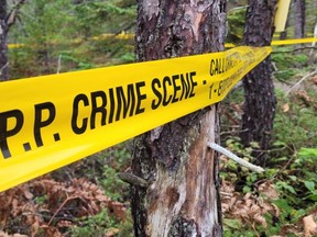 OPP crime scene tape marks off a wooded area near Scugog Lane in Northern Bruce Peninsula after police discovered a body Sunday while investigating a sudden death occurrence.