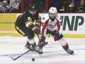 Justin O’Donnell, left, of the Sarnia Sting and Daniel D’Amico of the Windsor Spitfires battle for the puck on Thursday, October 7, 2021 at the WFCU Centre in Windsor, Ont.  (Dan Janisse/The Windsor Star)
