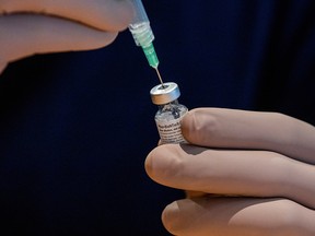 A health-care worker prepares a dose of the Pfizer/BioNTech coronavirus vaccine at Woodbine Racetrack pop-up vaccine clinic in Toronto on May 5, 2021.