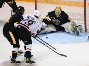 Owen Sound Attack's Ethan Burroughs (29) races Sarnia Sting's Brayden Guy to a loose puck in front of Sting goaltender Anson Thornton in the first period at the Harry Lumley Bayshore Community Centre in Owen Sound, Ont., on Saturday, October 30, 2021. Greg Cowan/The Sun Times