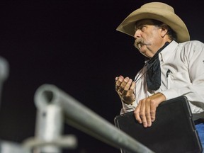 A bull riding scoring judge holds his stopwatch as he observers a bull rider Friday night at the RAM Invitational Bull Riding Jackpot held at the 2021 Tweed Stampede & Jamboree in Tweed, Ontario. ALEX FILIPE