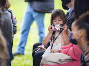 Kylee Wyatt, the daughter of Major Charles Wyatt, the great-grandson of Dr. James B. Collip, plays with a cellphone as speakers discuss the global impact of her great-great-grandfather Saturday in Belleville, Ontario. ALEX FILIPE