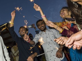 Diwali revellers wave sparklers as they dance and celebrate the festival of lights Sunday in Belleville, Ontario. ALEX FILIPE