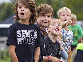 Youngsters (from left) Sawyer van Engen, age 7; Jack Saunders, 7; Theo Saunders, 5; Claire van Engen, 4 and her brother Myles van Engen marvel at the sight of snowmobiles racing on grass at the Burford Fair on Sunday.