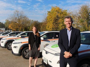 Rochelle Rumney, Brantford's climate change officer, and Andy McMahon, chief building official and director of building services, pose with new electric vehicles for building inspectors.