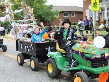 A couple of parade participants wave to the crowd on Saturday during the Waterford Pumpkinfest parade. Michelle Ruby