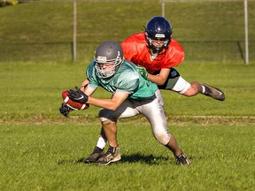 Carter Christilaw takes down receiver Jackson Smiley during a St. John's College senior boys football practice. Brian Thompson