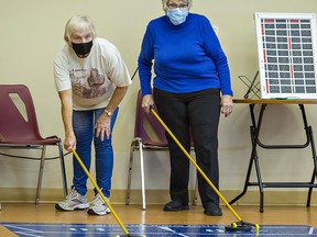 Mary Lou Oakes (left) and Gertrude Rideout take part in a floor shuffleboard match on Wednesday at the Simcoe Seniors Centre.