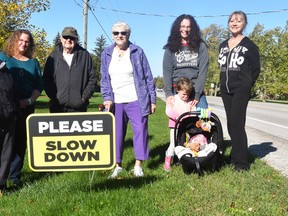 Jean Johnston (left), Lori Crowley, Bob and Joyce Blowers, Allison Fuller with children Taylor and Maxine, and Jan Law are just some residents of the village of Brodhagen that want to remind all drivers that pass through their community to slow down. "The last two years have been the worst," they say, and 28 'Please Slow Down' lawn signs have been erected around the village. ANDY BADER/MITCHELL ADVOCATE