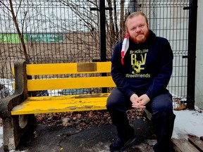 Leigh Bursey, a Brockville city councillor and homelessness awareness advocate, sits in late 2020 by a plaque at the city's downtown parkette, at the corner of King and John streets, in memory of a homeless man who died earlier this year, and to raise awareness of homelessness in the community.  (FILE PHOTO)