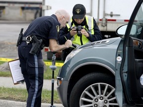 Ontario Provincial Police technical traffic collision investigators help Brockville police investigate a serious collision between a vehicle and a pedestrian at the intersection of Parkedale Avenue and Ormond Street on Friday. (RONALD ZAJAC/The Recorder and Times)