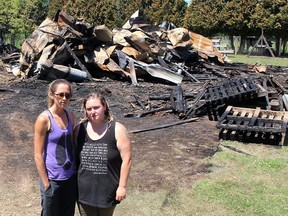 Lauren Edwards (left), founder of Charlotte's Freedom Farm, and Christine Rettig, a staffer who rescued several animals, stand in front of a barn destroyed in a fire at the Brook Line facility near Chatham just before midnight on July 1, 2020. Rettig has been charged with two counts of arson, one in connection to the July 2020 blaze and the other count in connection to a trailer that caught fire on the property on June 20. Ellwood Shreve/Postmedia Network