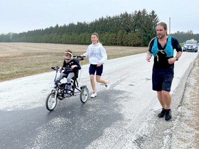 Kevin Owen is shown running with Jackie Lundy and daughter Sydney, a children's treatment centre client, during his recent shore-to-shore marathon fundraiser. (Handout)