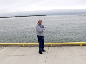 Erieau resident Jeff Vidler stands in front of a gap between the sand spit that is part of the tip of Rondeau Provincial Park on the left and the remnants of where the sand spit was once located, before being pushed by powerful waves and winds over the decades. Ellwood Shreve/Postmedia