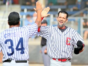 Mark Shadd (right) of Team Grey is congratulated by Mike Hadden after scoring in a slo-pitch game played by descendants of the 1934 Chatham Colored All-Stars at Fergie Jenkins Field at Rotary Park in Chatham on Oct. 2. Mark Malone/Postmedia Network