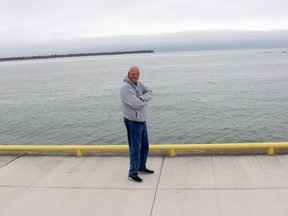 Lifelong Erieau resident Jeff Vidler stands in front of a gap between the sand spit that is part of the tip of Rondeau Provincial Park on the left and the remnants of where the sand spit was once located, before being pushed by powerful waves and winds over the decades. ELLWOOD SHREVE/Chatham Daily News/Postmedia