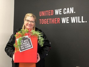 Handout
Courtney Wells, business liaison for United Way of Chatham-Kent, displays a sign promoting the 12 Days of Giving that begins on Monday.