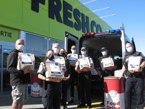 Representatives of FreshCo, the Agape Centre food bank, the Cornwall Police Service and CPS auxiliary holding food donation bags at the Cram the Cruiser event. Photo on Friday, October 8, 2021, in Cornwall, Ont. Todd Hambleton/Cornwall Standard-Freeholder/Postmedia Network