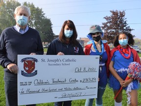 From left to right, Children's Treatment Centre president Don Fairweather, St. Joseph's Catholic Secondary School principal Joy Martel, students Rhiannon Beckstead and Jordan Ham presenting a fundraising cheque on Friday October 8, 2021 in Cornwall, Ont. Shawna O'Neill/Cornwall Standard-Freeholder/Postmedia Network