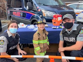 Two Cornwall Police Services employees pose with Caleb Pulice, center, who was excited to attend the Fire Prevention Open House, so much so that he dressed up for the occasion. Handout/Cornwall Standard-Freeholder/Postmedia Network
