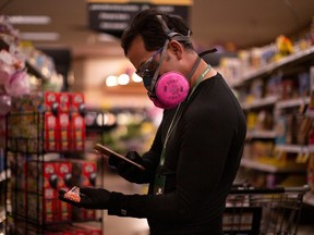 An Instacart employee uses his phone to scan an item for a delivery order he is preparing in Tucson, Arizona. Instacart operates in most major Canadian cities as well.