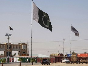 Pakistani flags, centre, and the Taliban flag, right, flutter on their respective border sides as seen from the Pakistan-Afghanistan border crossing point in Chaman on Aug. 18.