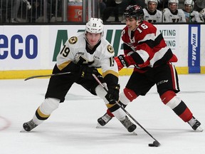 Thomas Johnston of the Ottawa 67's takes a hooking penalty while trying to stop Kingston Frontenacs forward Paul Ludwinski in Ontario Hockey League action at the Leon's Centre in Kingston on Friday.