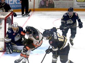 Kirkland Lake Gold Miners' Christian Genova and Hearst Lumberjacks' Robbie Rutledge battle for the puck in front of Miners' goalie Glen Crandall.