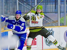 Josh Currie of the North Bay Battalion takes Nick DeGrazia of the Sudbury Wolves for a tour of the boards in their Ontario Hockey League game, Monday, as the Troops hosted their traditional Thanksgiving Day matinee. Sean Ryan Photo