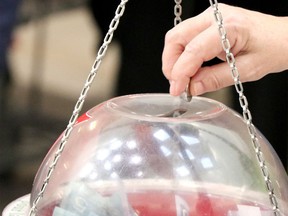 A donor adds some coins to a Salvation Army kettle in this file photo.
(files)
