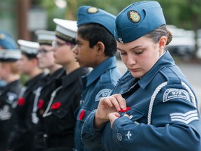 Air Cadet Sgt. Amanda Patterson pins a poppy on her uniform during a past remembrance ceremony. This year marks the 100th anniversary of the Remembrance Day poppy.  Wayne Cuddington