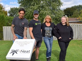 Beekeeper Dan Heffernan (left), Jonny Sikkema, founder of Bzz Box, Leeana Newton, brand director of Neat Cannabis Company Ltd., and Shea Sullivan, assistant manager of the Komoka store, stand in front of the Neat Cannabis Company beehive. Calvi Leon/Postmedia