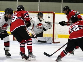 Evan Dowd (12) of the Mitchell Hawks follows his shot over the shoulder of Walkerton Hawks' goalie Kyle RIvers (31) during PJHL Pollock regular season action Oct. 6 in Mitchell, an 8-1 victory. Also pictured are Hawks' Tyson Hall (19) and Braeden Burdett (9).