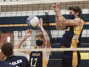 St. Mike’s senior boys’ volleyball players Ryan Middegaal (17) and Seth Huygen (11) get up for a block on St. Anne’s player during Thursday’s season opener in Stratford. The Warriors won in three sets.