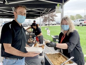 Dean Pearson, the operations manager at Cabot Canada in Sarnia, is served up some apple crisp by Kim Craigman, human resources specialist and United Way volunteer at the annual United Way lunch. All donations by employees and retirees at Cabot are matched by the company. United Way photo