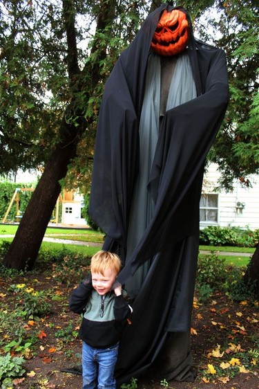 Two-year-old Brier Hunter doesn't seem at all frightened by the creepy monster decorating the property at his Main Street home during the 2021 Waterford Pumpkinfest celebration on Saturday, Oct. 16. MICHELLE RUBY/POSTMEDIA